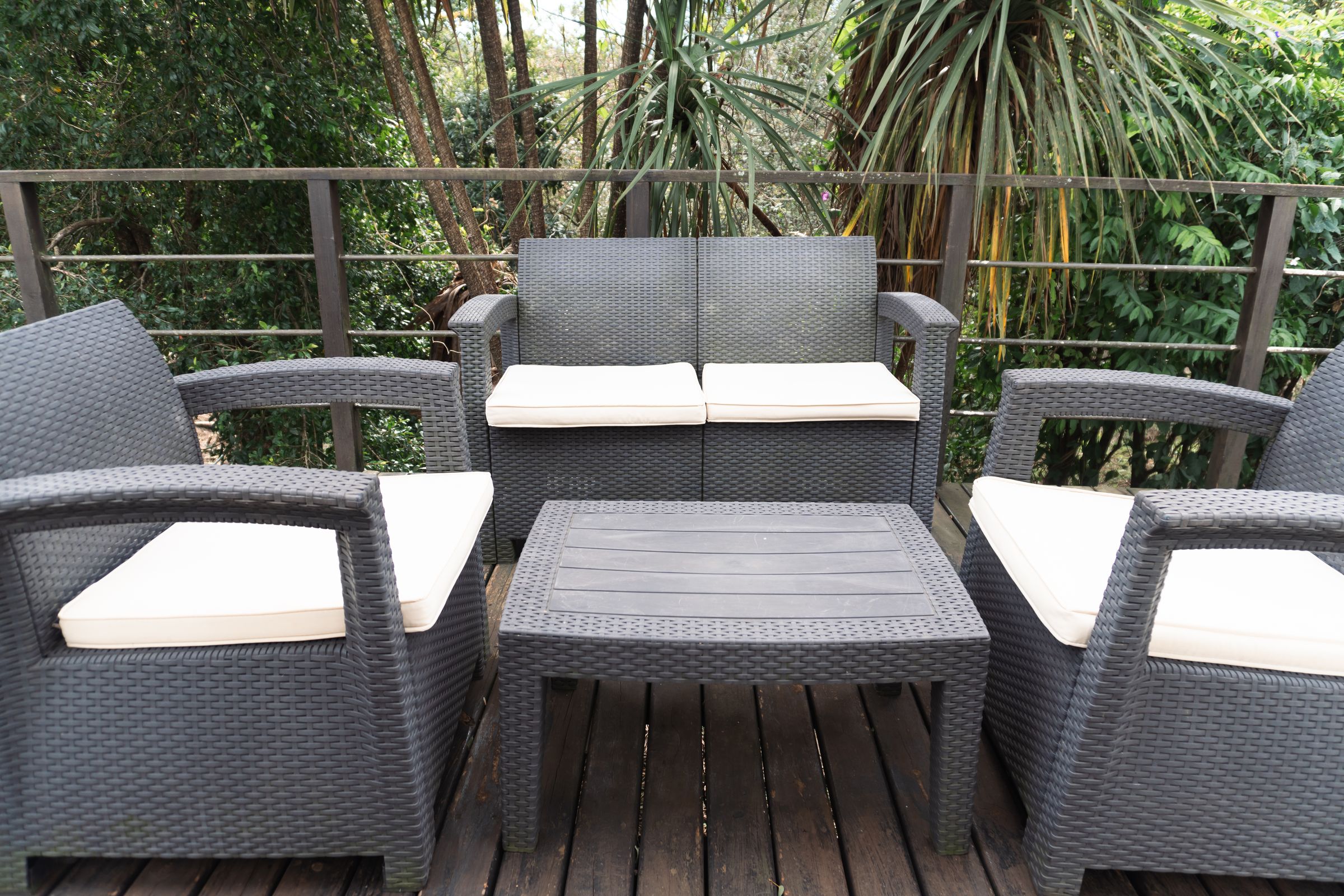 Wicker chairs on the timber deck among the trees