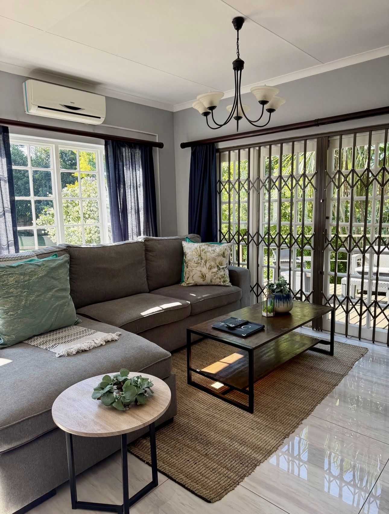 A second lounge with a grey corner couch and doors onto the balcony