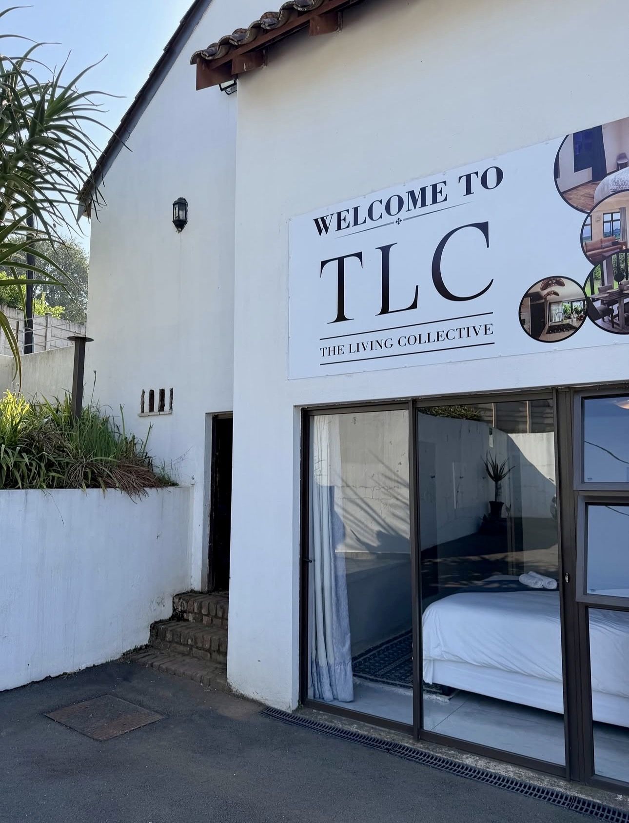 The TLC welcome sign on a white wall beside a ground floor bedroom
