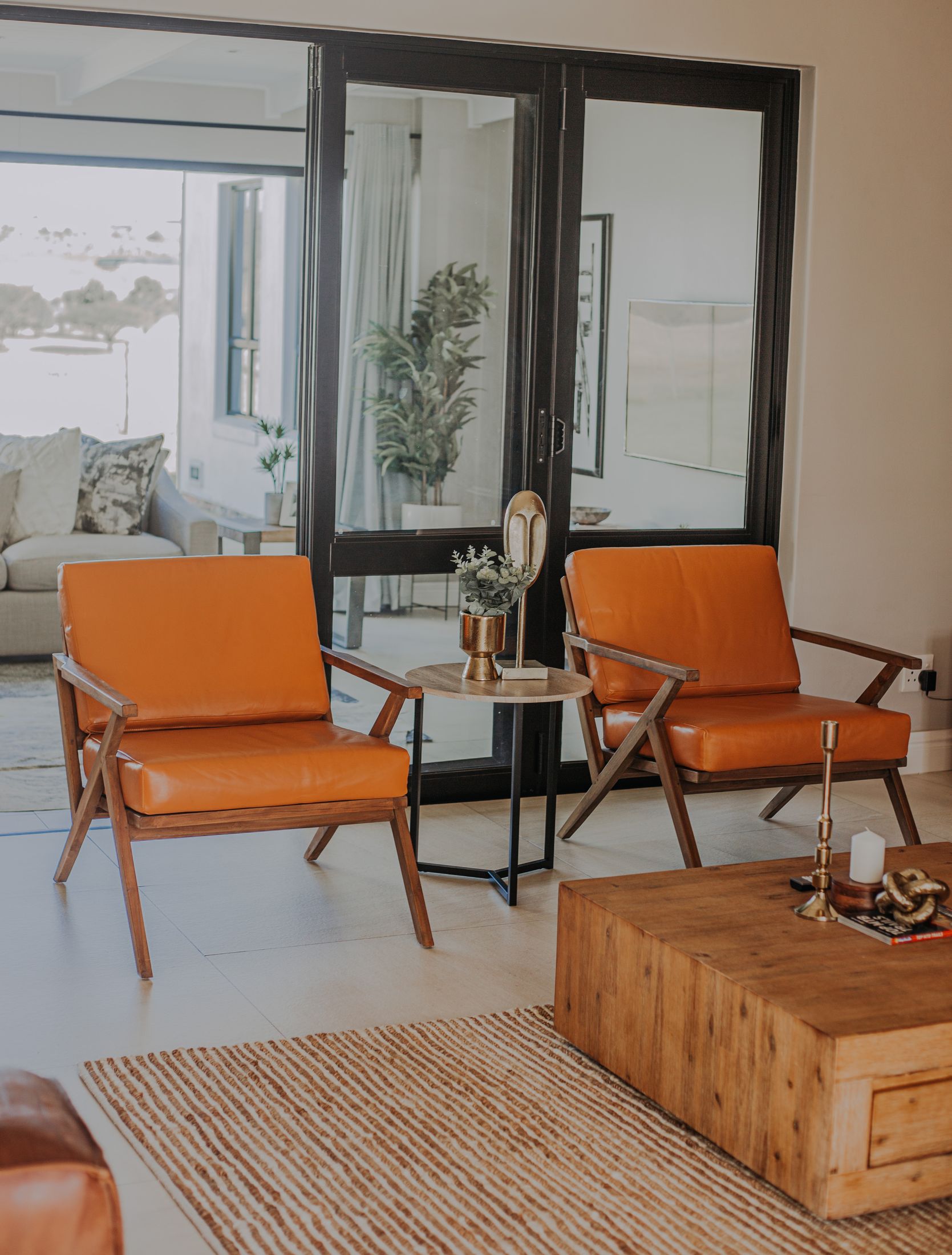 Two orange leather chairs by the glass doors