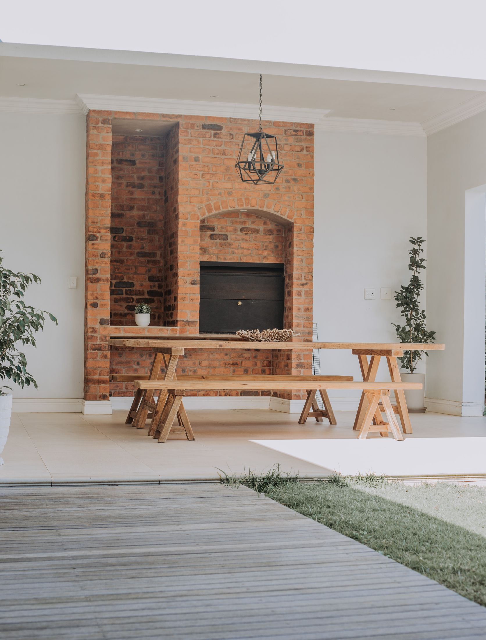The covered patio with a brick braai and a long timber table