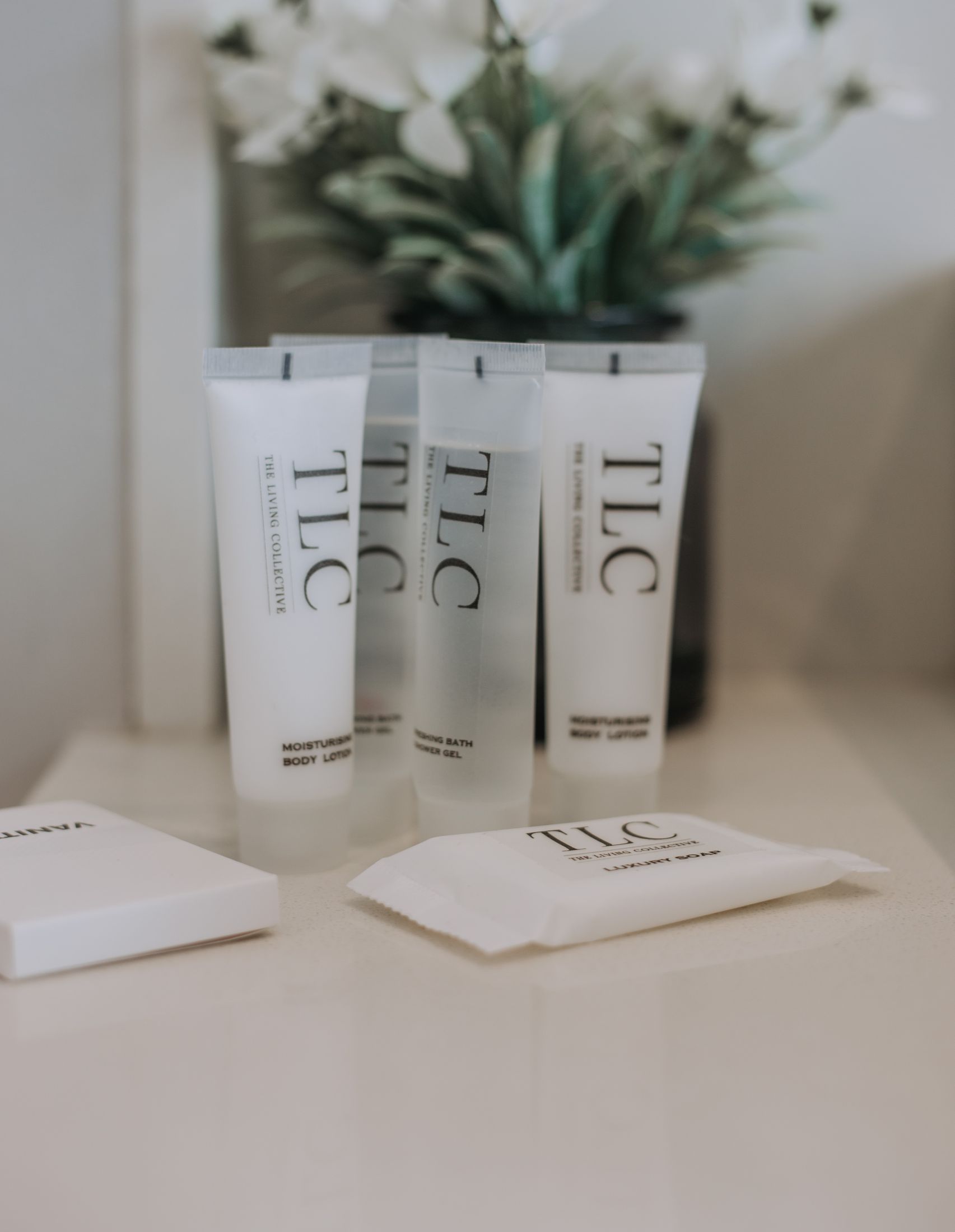 TLC toiletries lined up on a bathroom counter