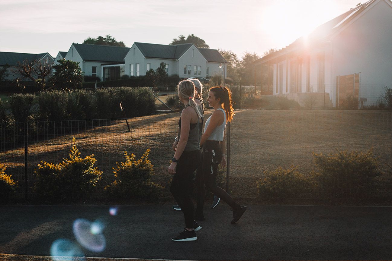 Two guests walking between the houses of the estate at sunset