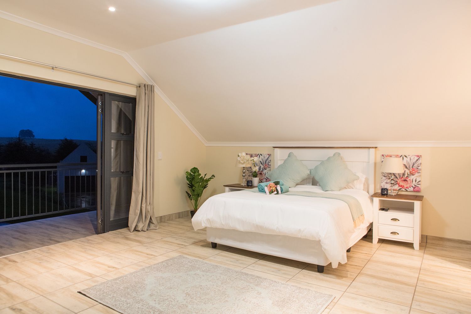 The Loft at Unit 6 at dusk, with a bed and a door onto the balcony