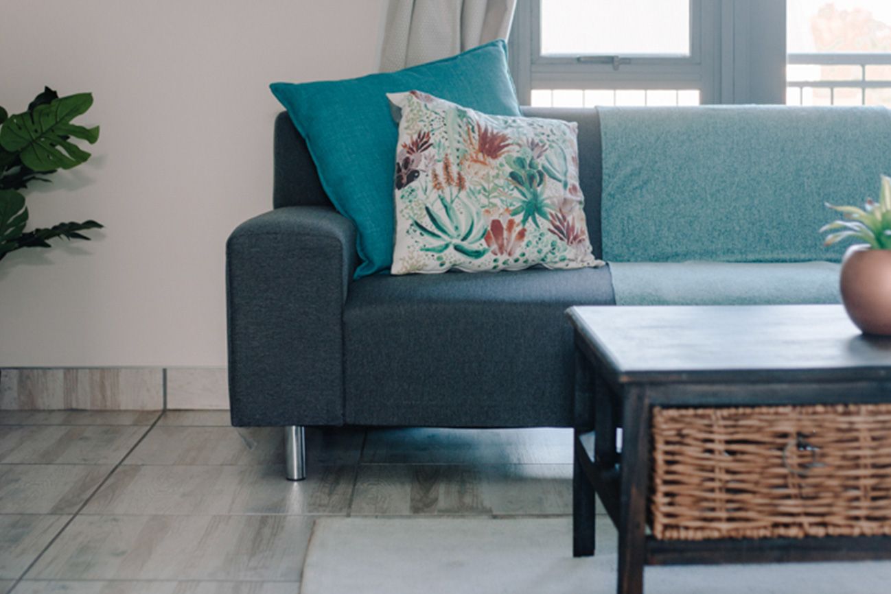 A blue couch with a floral cushion in a loft