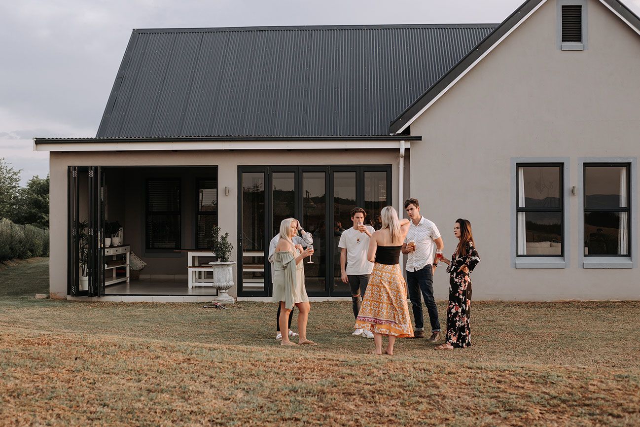 A family outside the front of a Gates at Hilton house with a grey roof