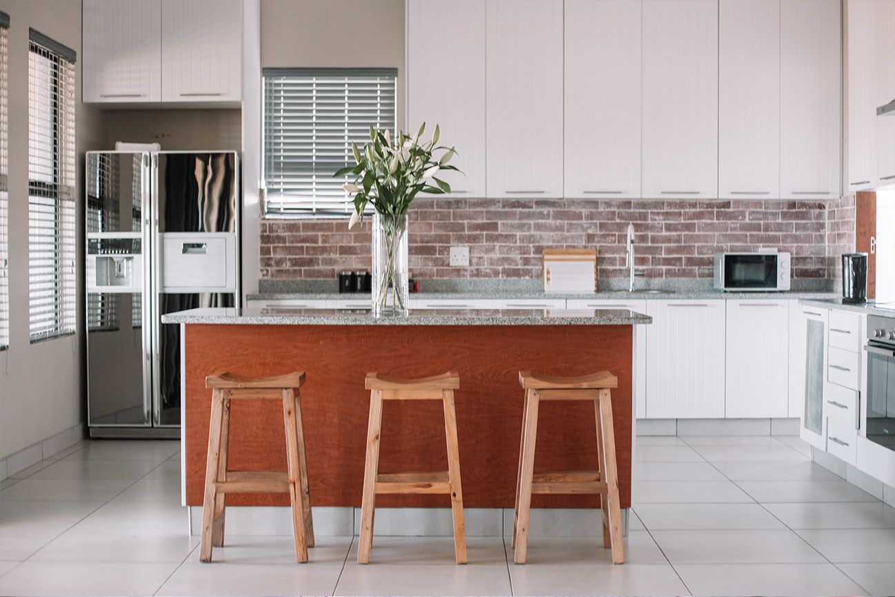 The Unit 5 kitchen with a timber island and three bar stools