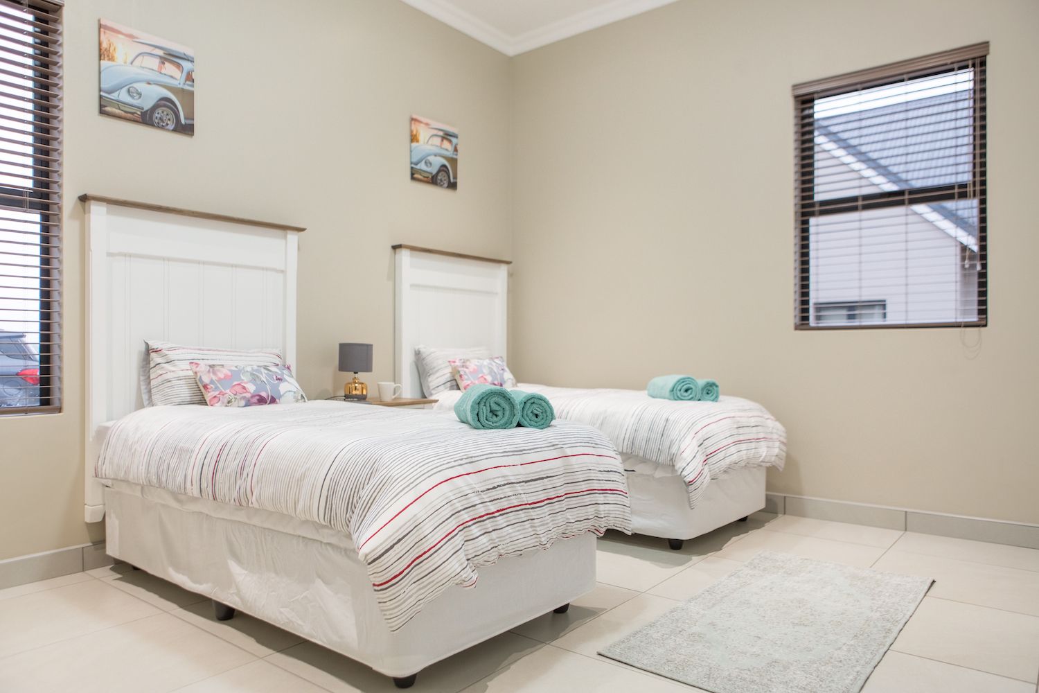 Two single beds made up with striped linen in Unit 5
