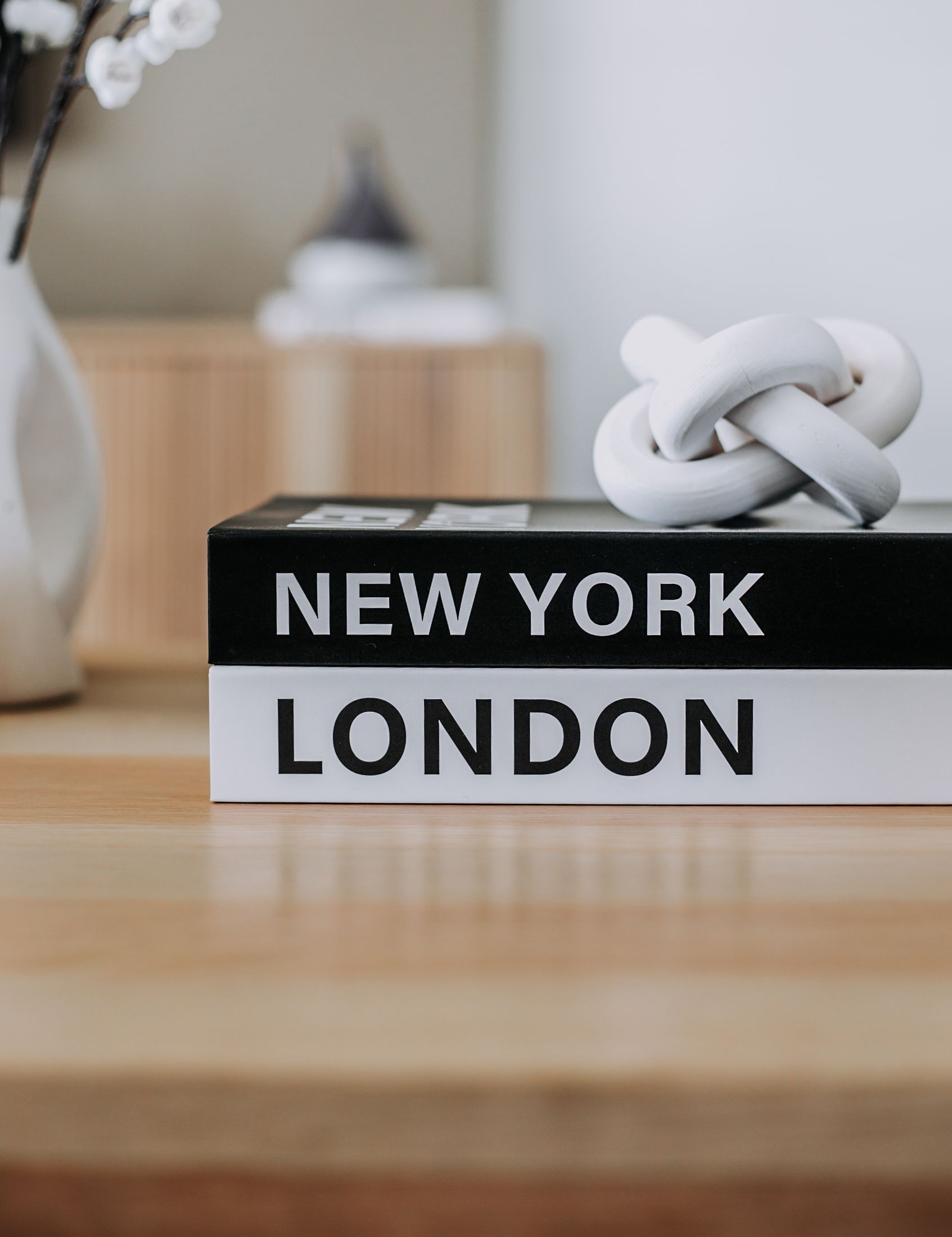 New York and London books with a white knot ornament on a shelf