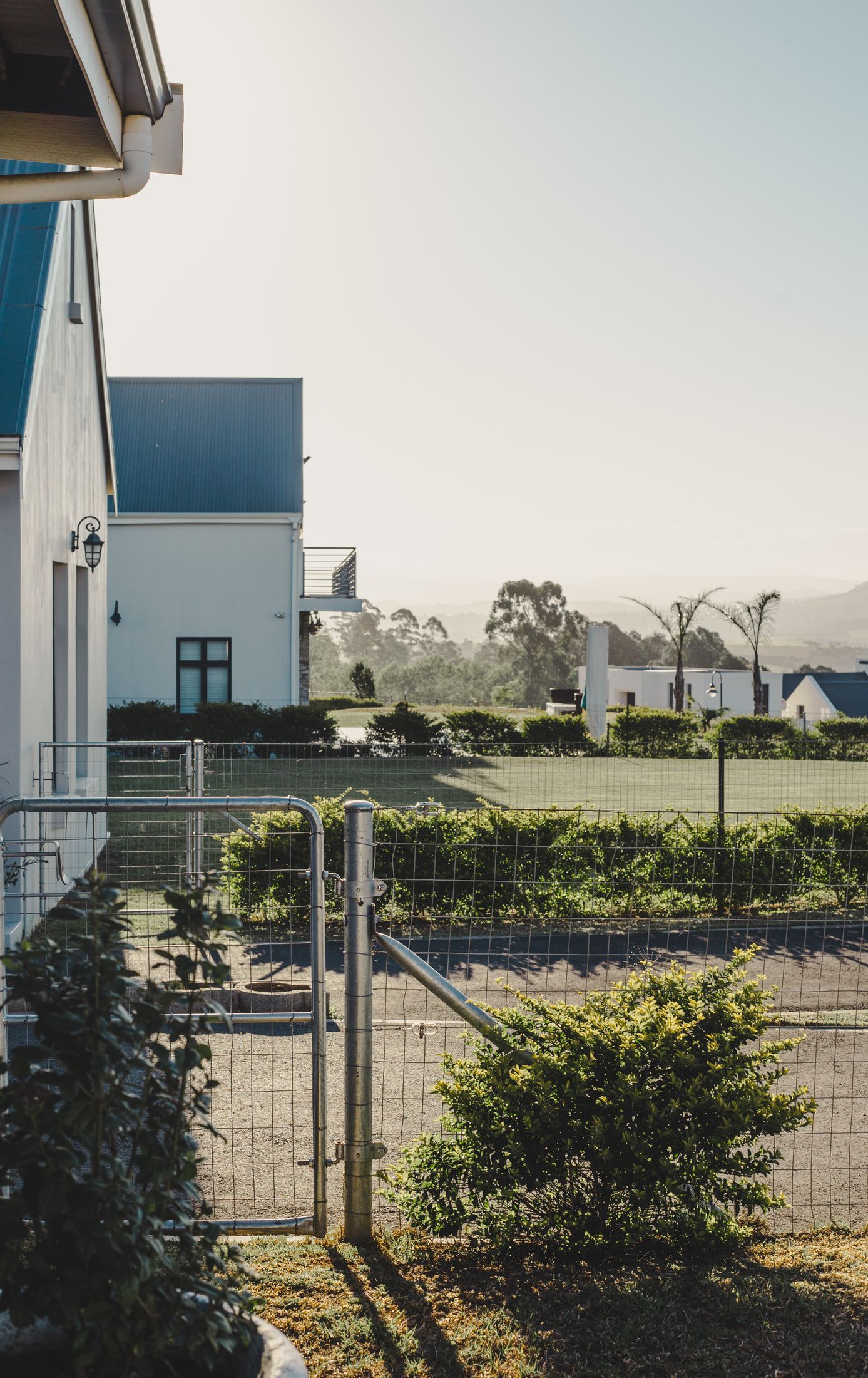 The view past the side gate across the estate to the hills