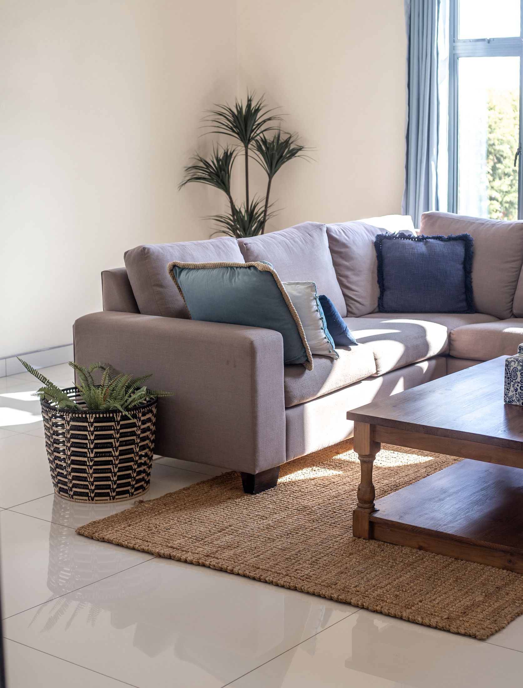 The Unit 6 lounge with a grey corner couch, a timber coffee table and a jute rug