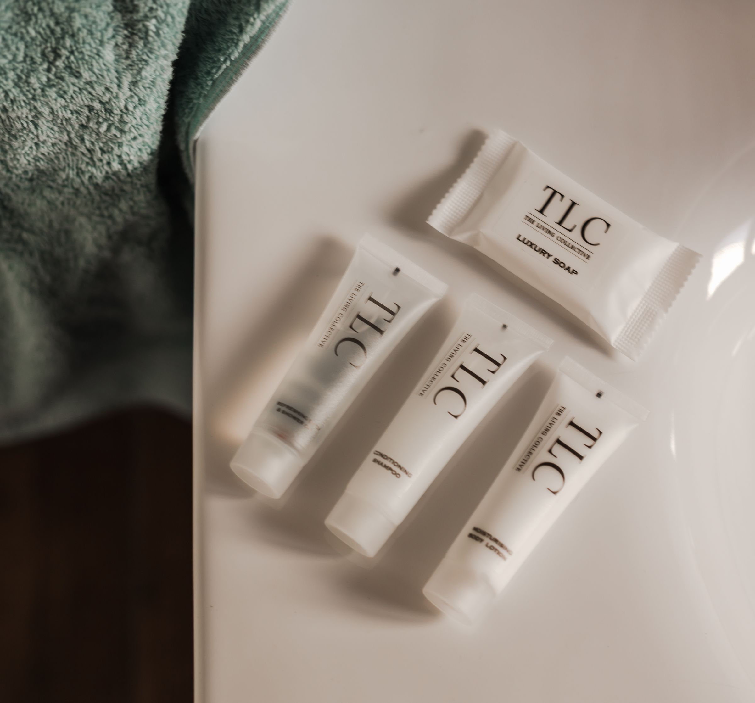 TLC soap and bottles on a white bathroom counter