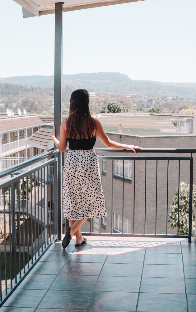 A guest on an apartment balcony looking over Pelham to the hills