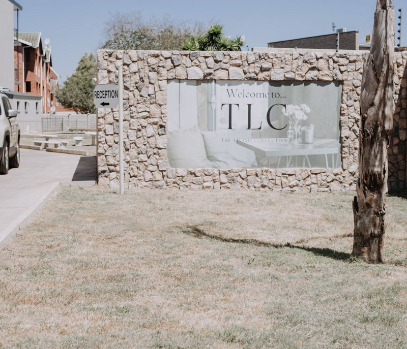The stone entrance wall with the TLC sign at Wenvic