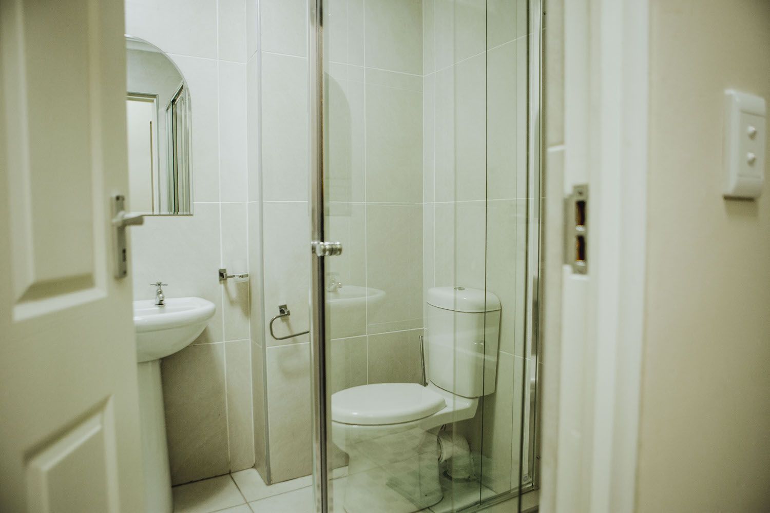 A long stay bathroom with a shower and basin